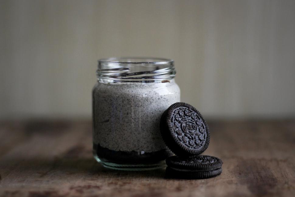 Free Image of Oreo Cookie and Jar of Cookies on Table 