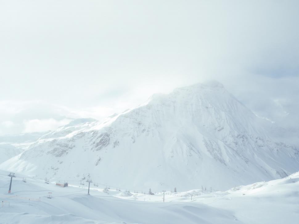 Free Image of Snow Covered Mountain With Distant Ski Lift 