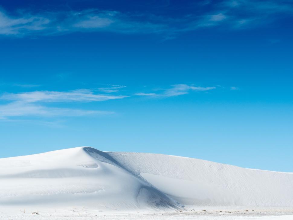 Free Image of Snow Covered Hill With Blue Sky Background 