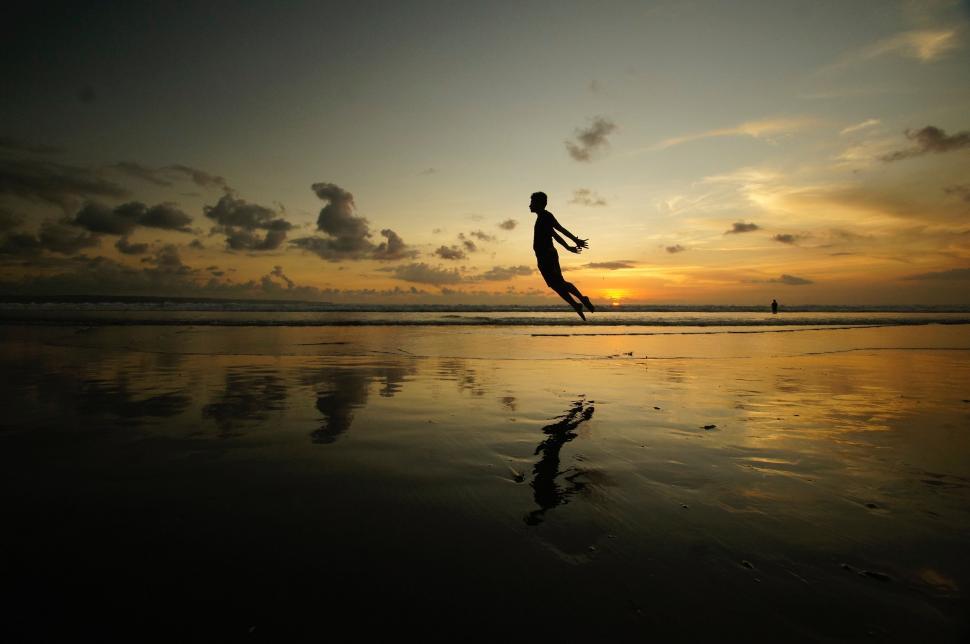 Free Image of Person Jumping in the Air on Beach 