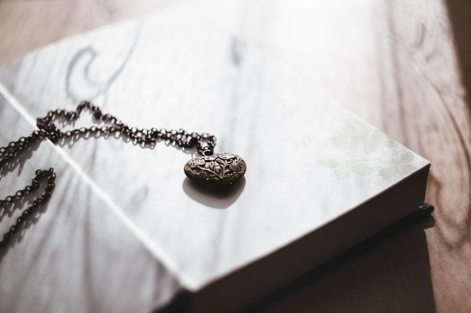 Free Image of Book With Necklace on Table 