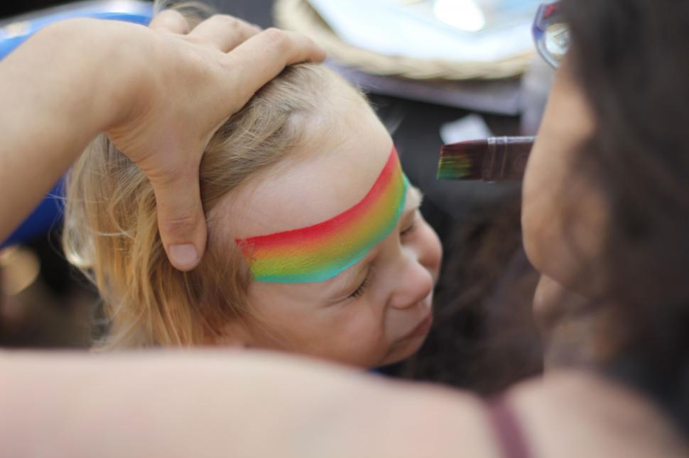 Free Image of Young Girl With Rainbow Face Paint 