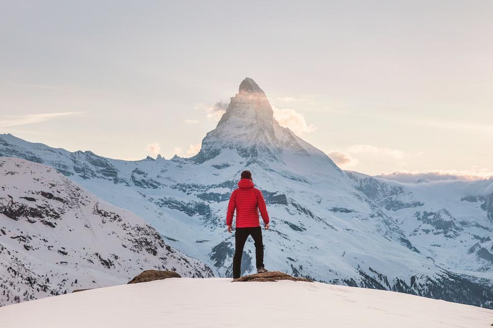 Free Image of Man Standing on Snow-Covered Mountain Summit 