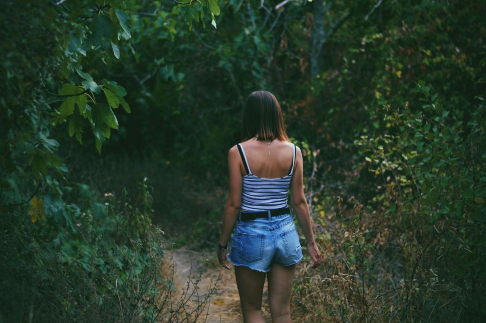 Free Image of Woman Walking Down Dirt Path in Woods 