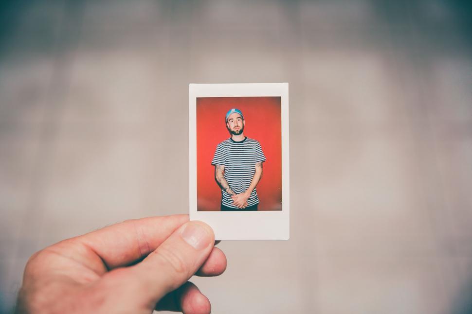 Free Image of Hand Holding Polaroid With Picture of Man 