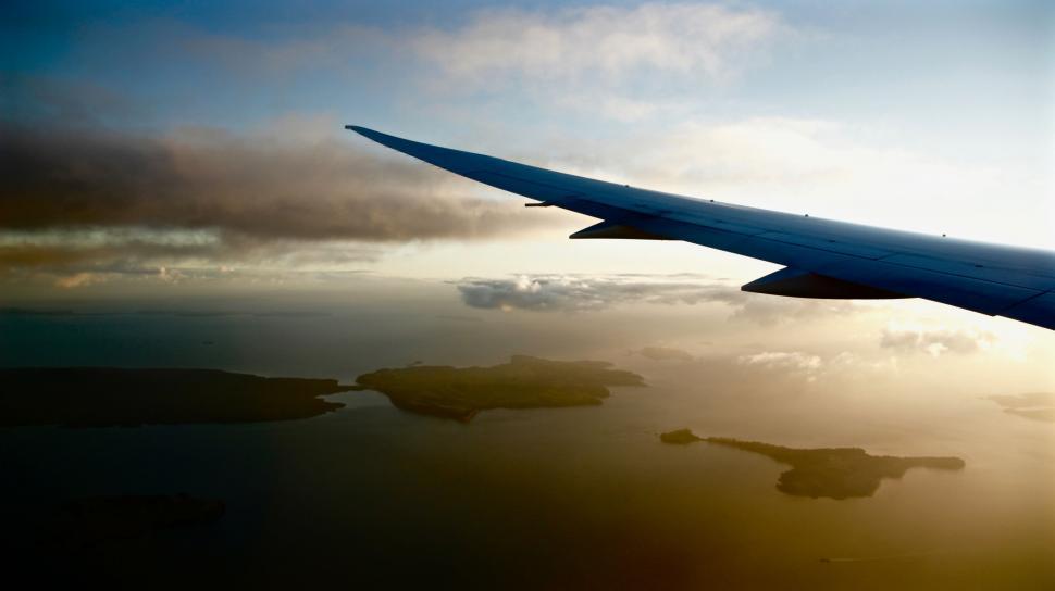 Free Image of Airplane Wing Soaring Above Body of Water 