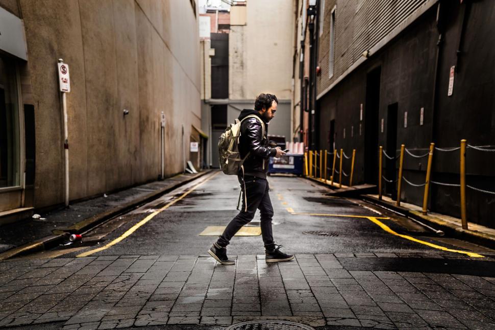 Free Image of Man Walking Down Street With Backpack 