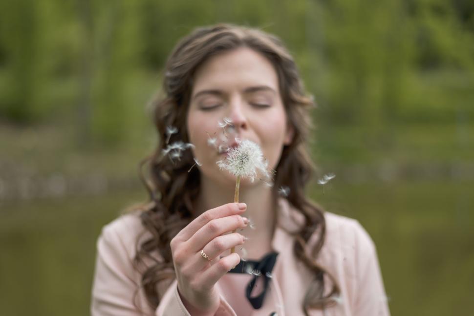 Free Image of Woman Blowing Dandelion With Eyes Closed 