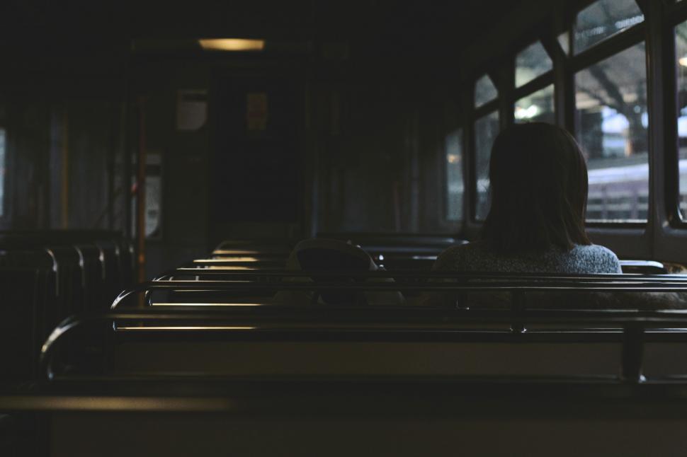 Free Image of Woman Sitting on a Train Looking Out the Window 
