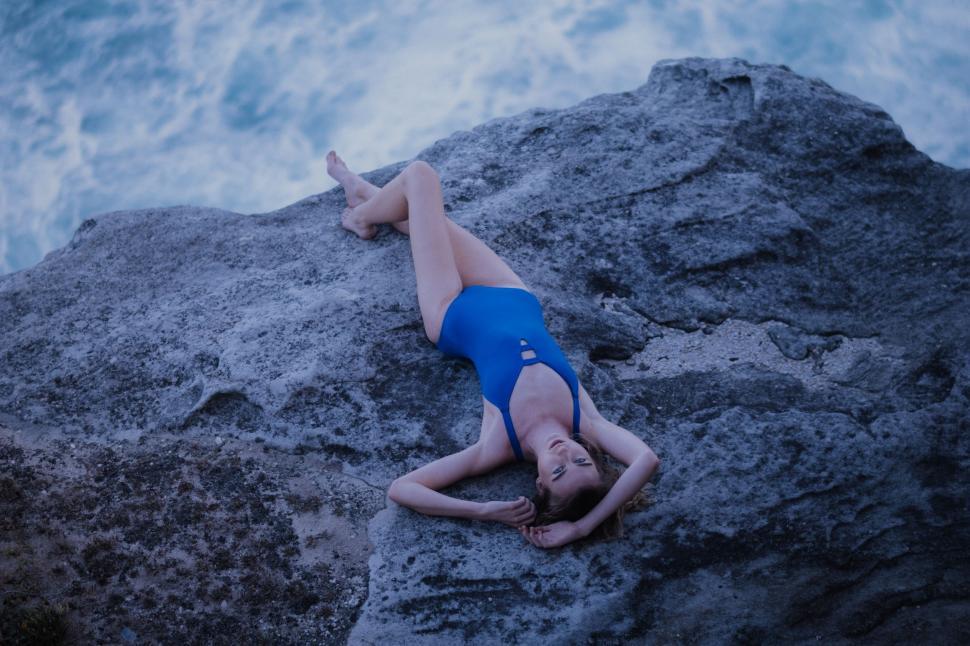 Free Image of Person Laying on Rock Near Ocean 