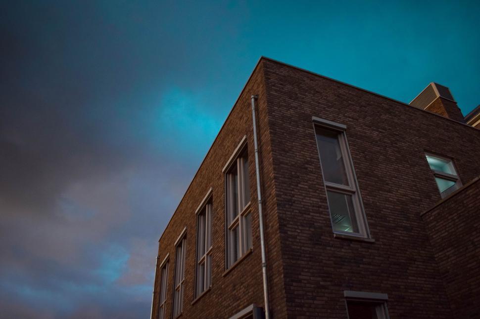 Free Image of Tall Brick Building Under Cloudy Sky 
