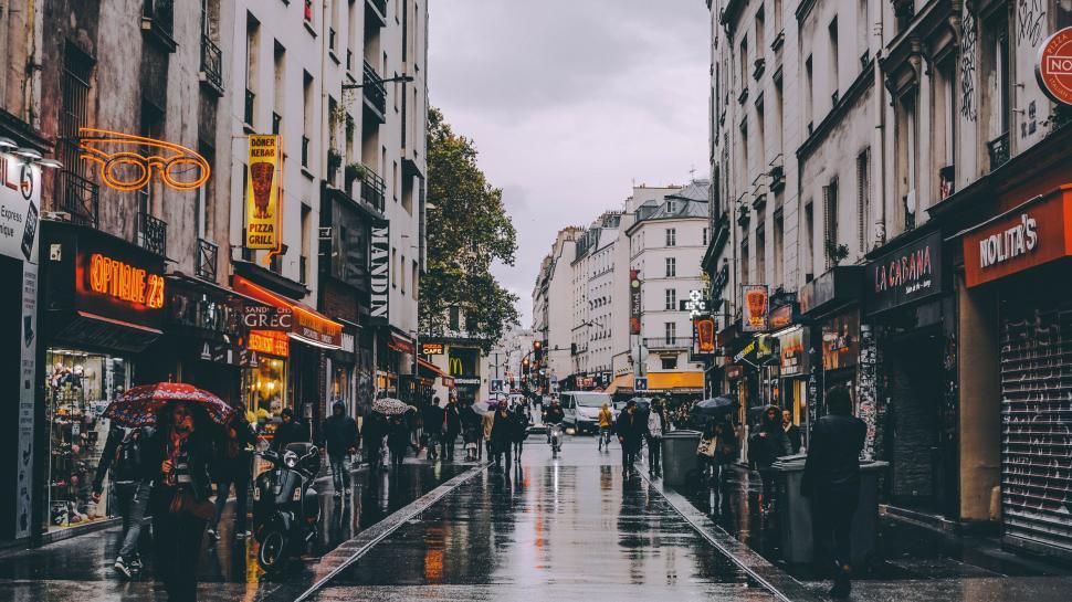 Free Image of Wet City Street With People Walking 