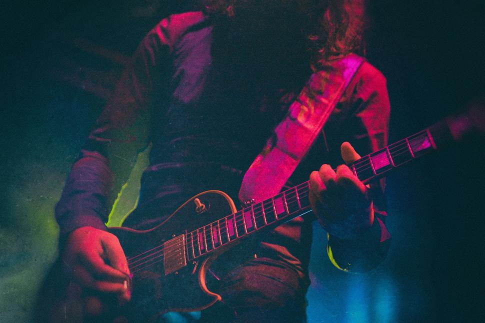 Free Image of Man With Long Hair Playing a Guitar 