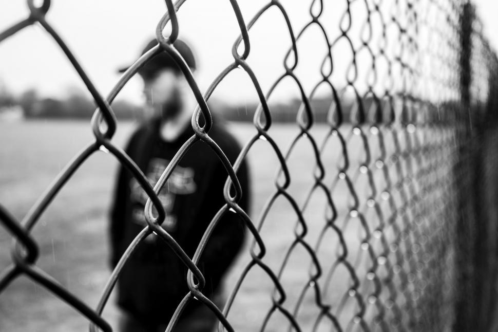 Free Image of Person Standing Behind a Fence 