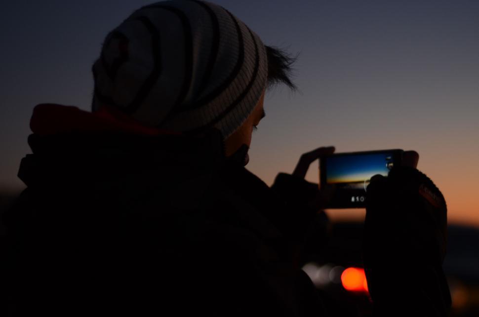 Free Image of Person Taking a Picture of a Sunset With a Cell Phone 