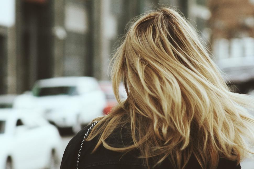 Free Image of Woman With Blonde Hair Walking Down the Street 