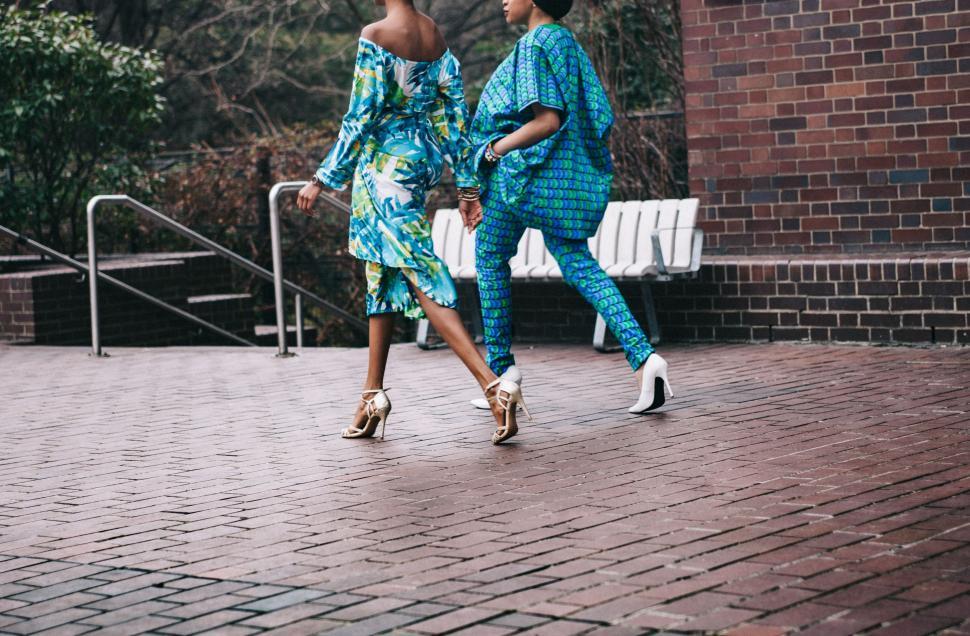 Free Image of Two Women Walking Across Brick Walkway 
