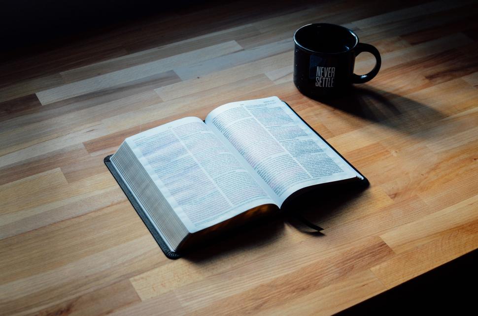 Free Image of Open Book and Coffee Mug on Wooden Table 