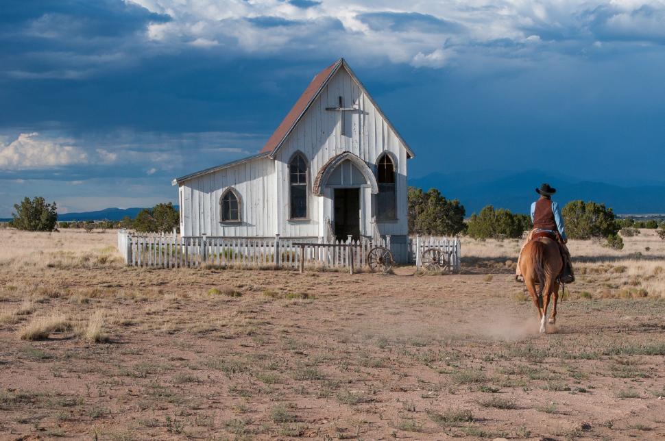 Free Image of Person Riding a Horse in Front of a Church 