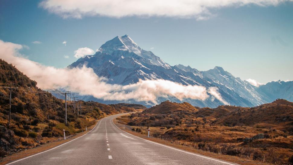 Free Image of A Long Road With a Mountain in the Background 