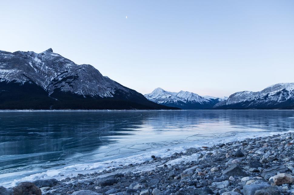 Free Image of Snow-Covered Mountains Surrounding Large Body of Water 