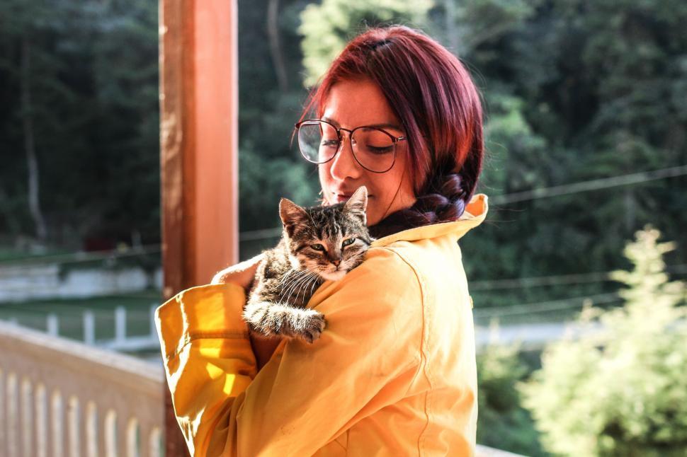 Free Image of Woman in Yellow Jacket Holding Cat 