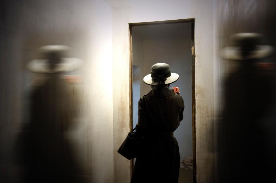 Free Image of Woman in Hat Standing in Front of Door 