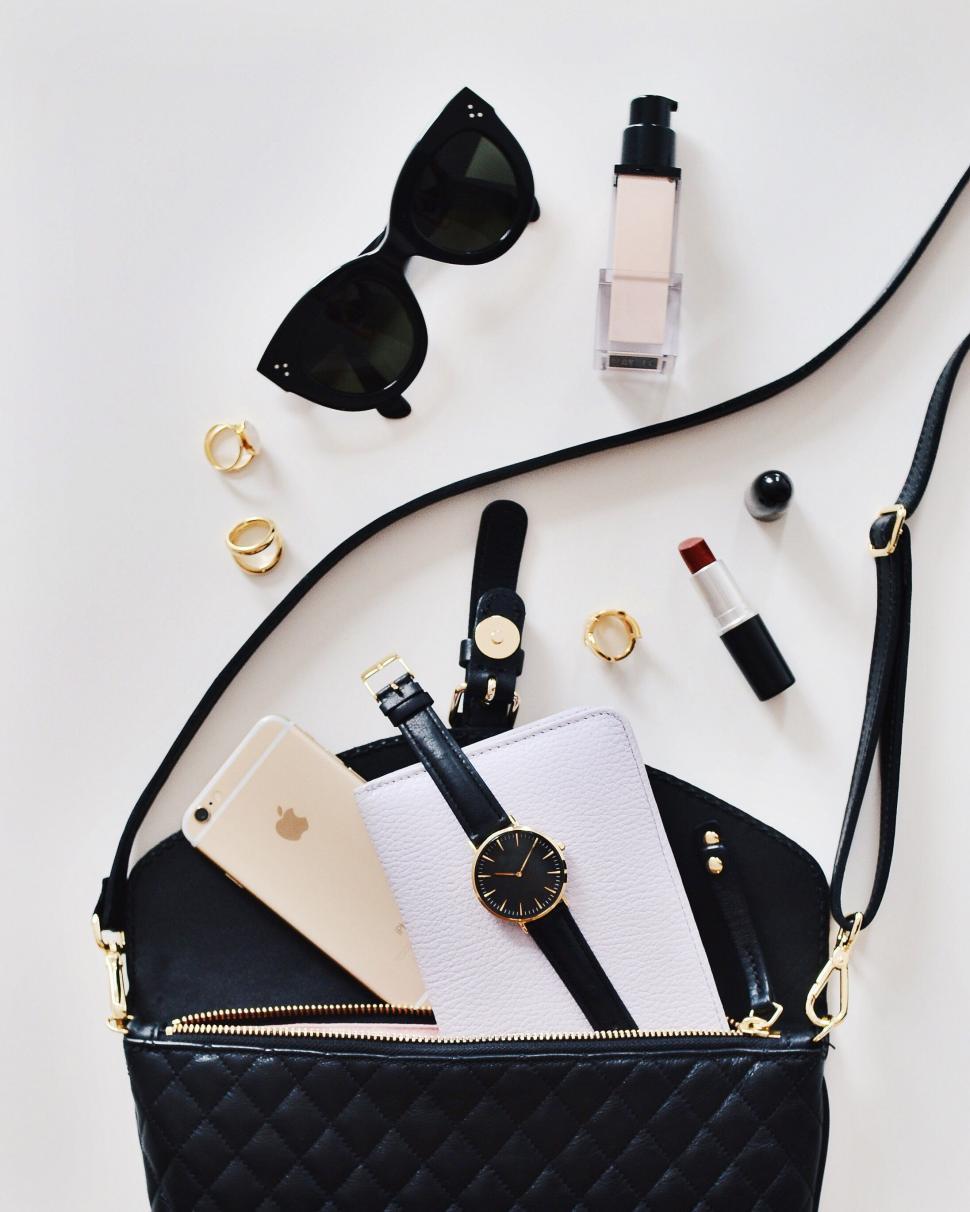 Free Image of Stylish Black and White Purse With Sunglasses, Cell Phone, Watch, and Accessories 