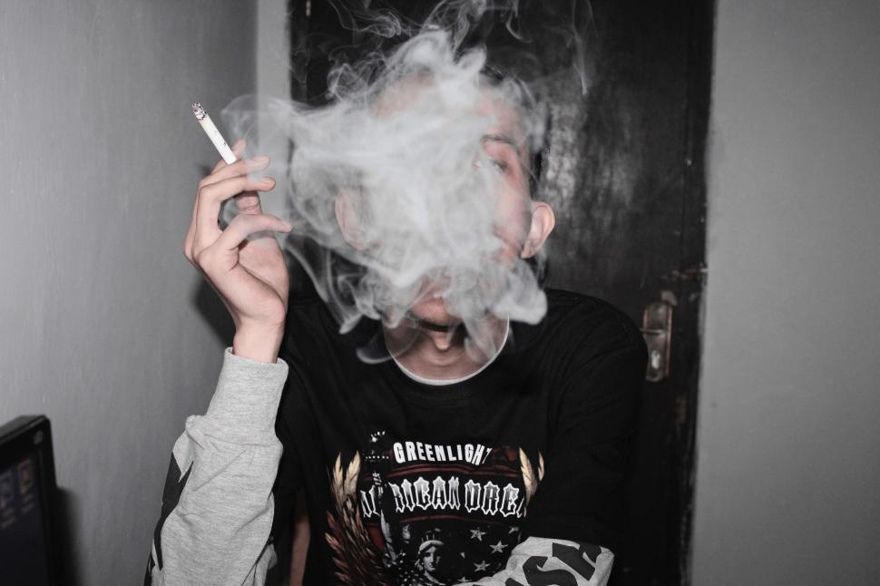 Free Image of Person Smoking a Cigarette in a Room 