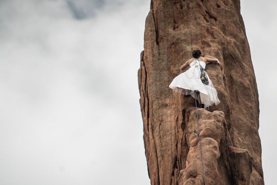 Free Image of Woman in White Dress Standing on Rock 