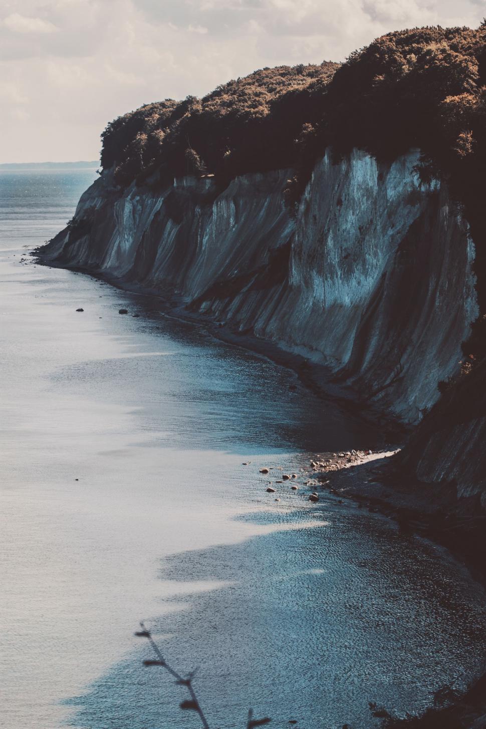 Free Image of Rocky Cliff Surrounding Body of Water 