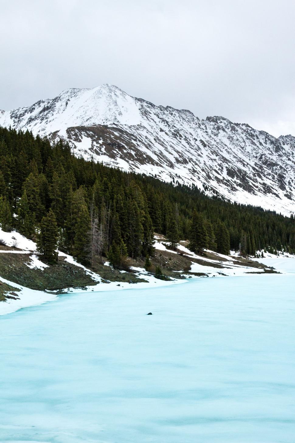Free Image of Majestic Body of Water Surrounded by Snow Covered Mountains 