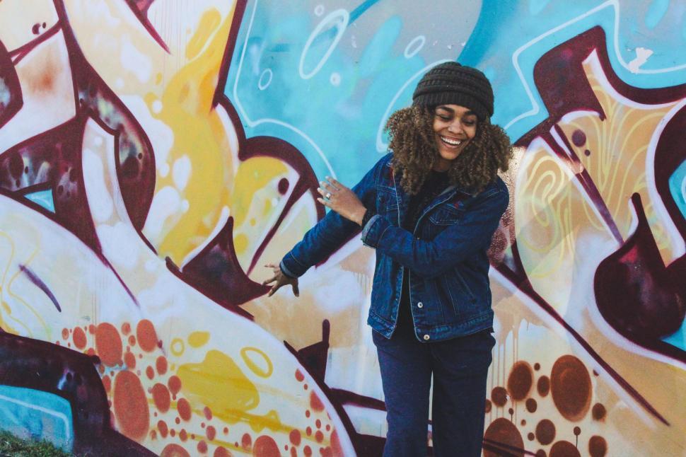 Free Image of Woman Standing in Front of Graffiti Wall 