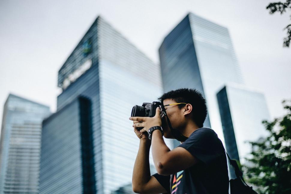 Free Image of Man Taking a Picture of a Building With a Camera 