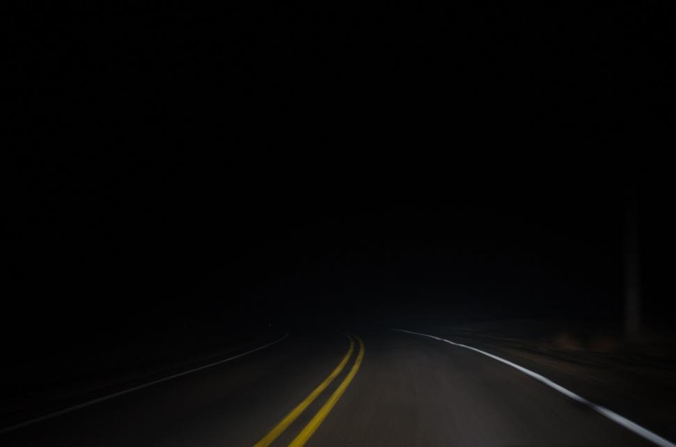 Free Image of Car Driving Down Dark Road at Night 