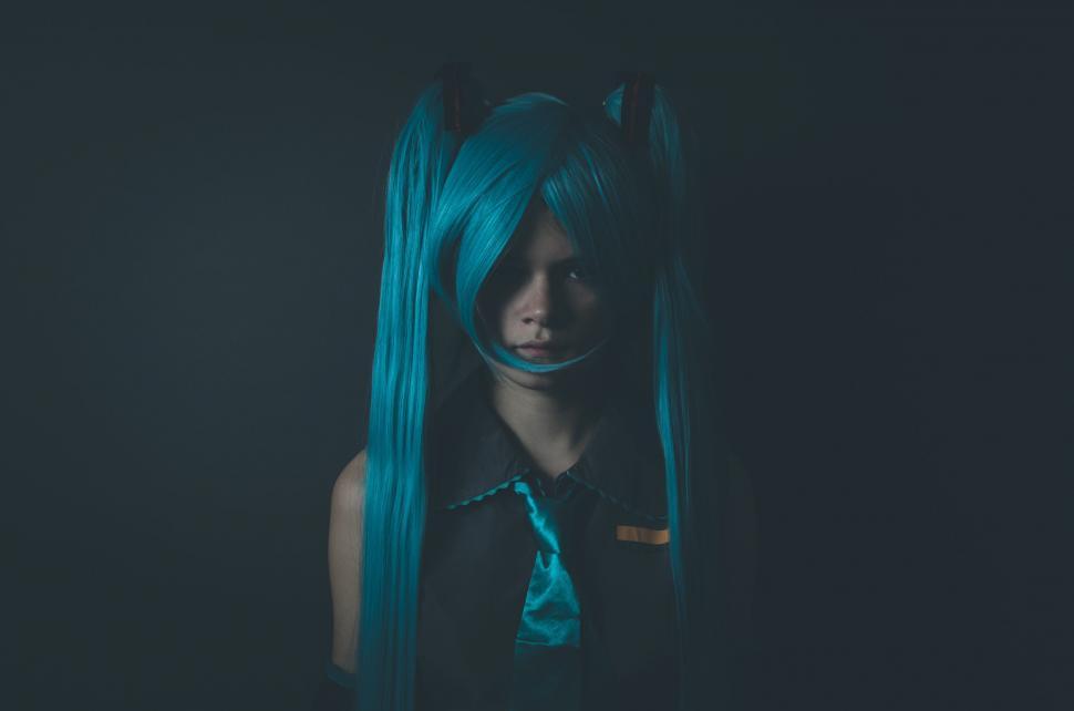 Free Image of Woman With Long Blue Hair Standing in Dark Room 