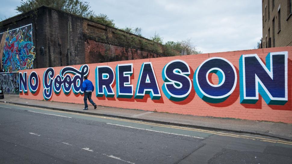 Free Image of Person Walking Past Wall That Reads No Good Reason 