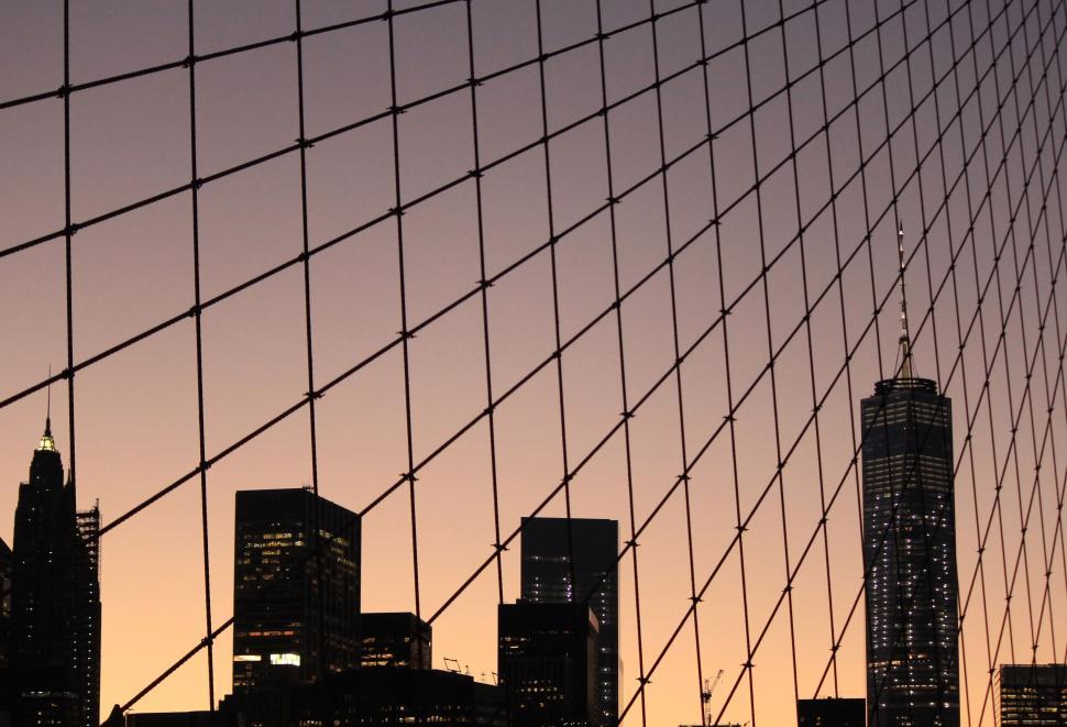 Free Image of City Skyline View Through Wire Fence 