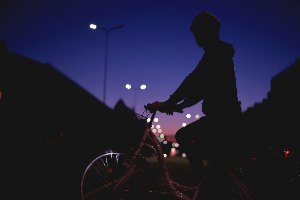 Free Image of Man Riding Bike Down Street at Night 