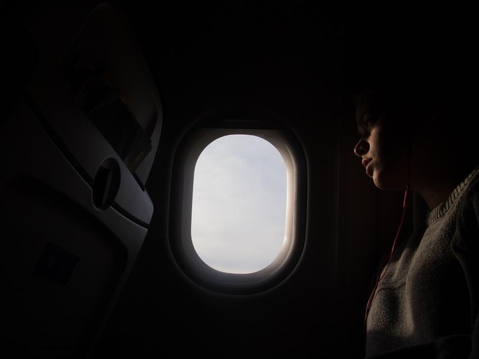Free Image of Woman Looking Out of Airplane Window 