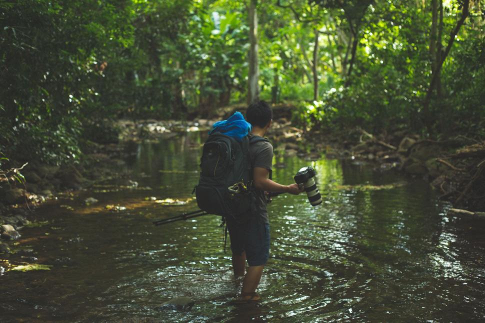 Free Image of Man Wading Through River With Backpack 
