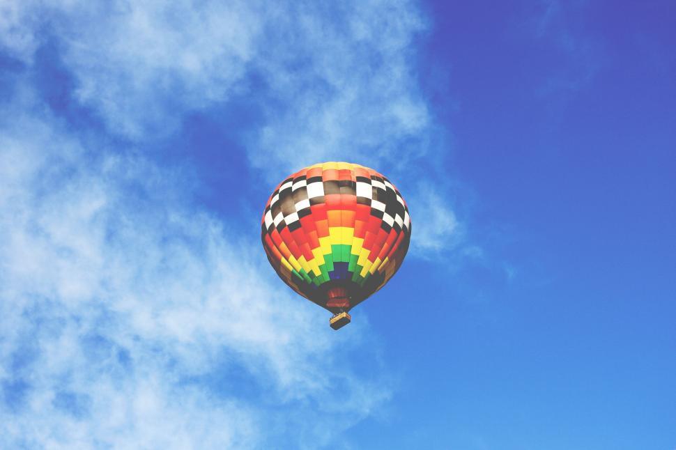 Free Image of Colorful Hot Air Balloon Flying Through Blue Sky 