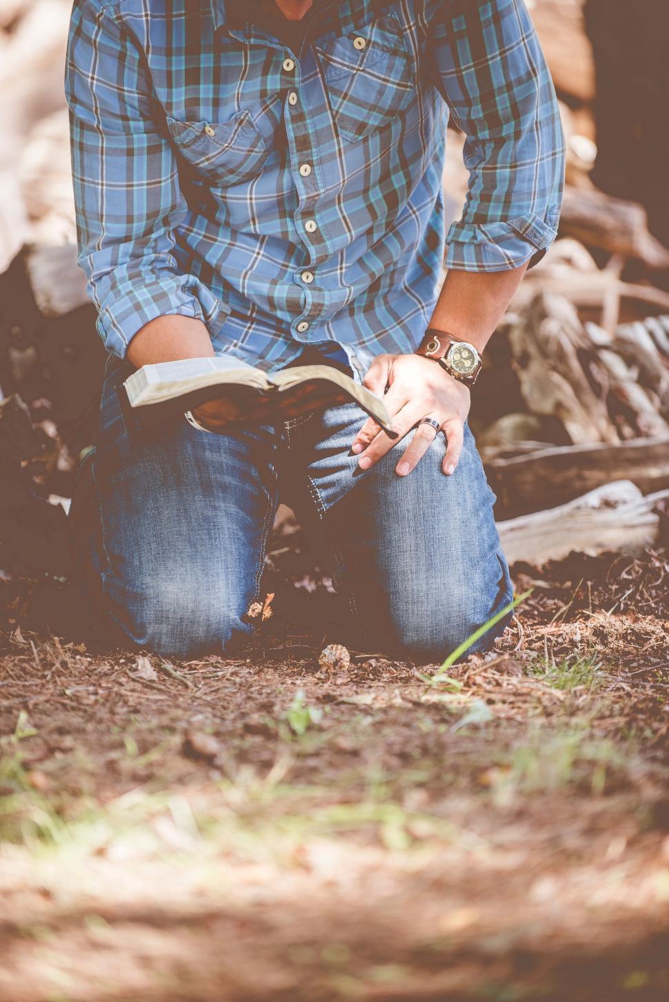 Free Image of Man Sitting on Ground Reading Book 