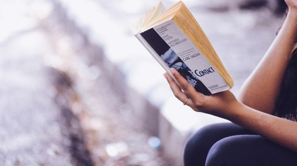 Free Image of Woman Reading Book While Sitting Down 