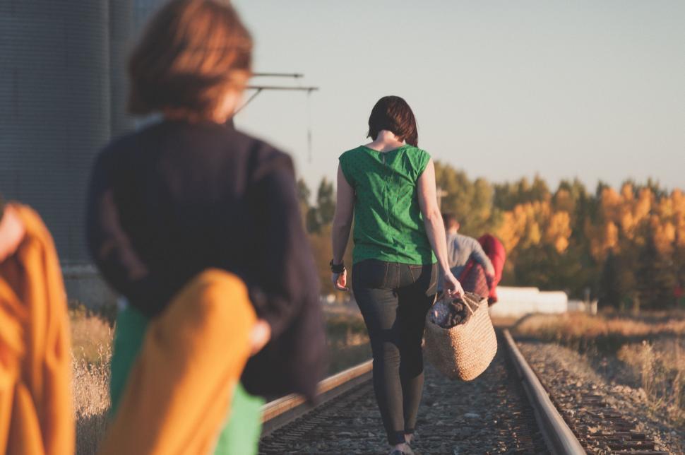 Free Image of Group of People Walking Down a Train Track 