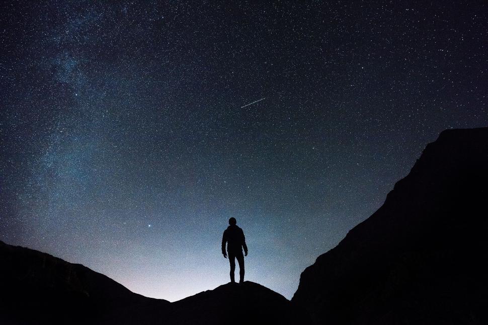 Free Image of Man Standing on Top of Mountain Under Night Sky 