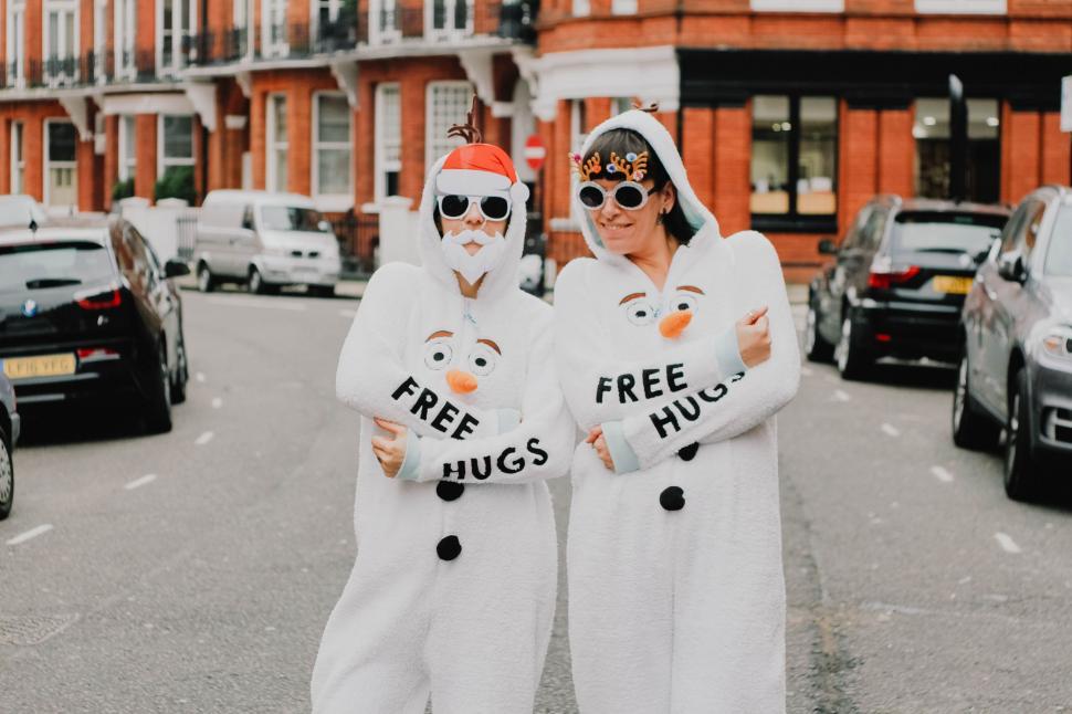 Free Image of Two People in White Costumes Standing in the Middle of a Street 