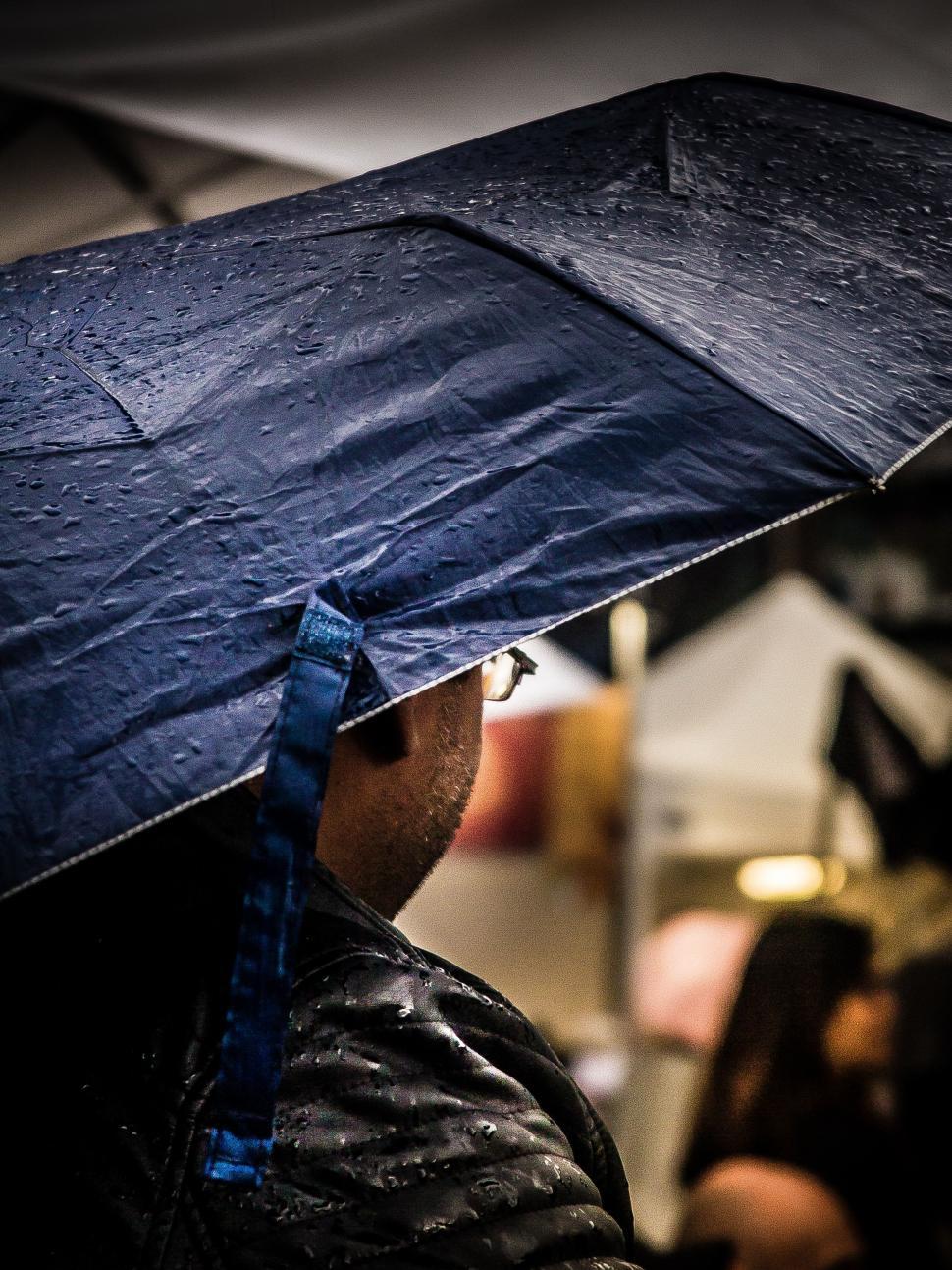 Free Image of Man Holding Umbrella in the Rain 