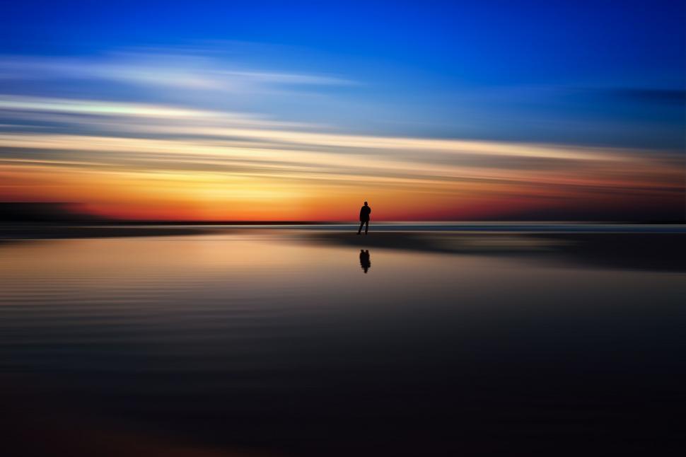 Free Image of Person Standing on Beach at Sunset 