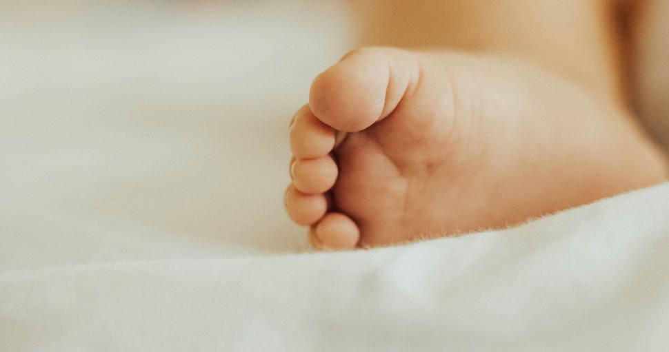 Free Image of Close Up of a Babys Foot on a White Blanket 
